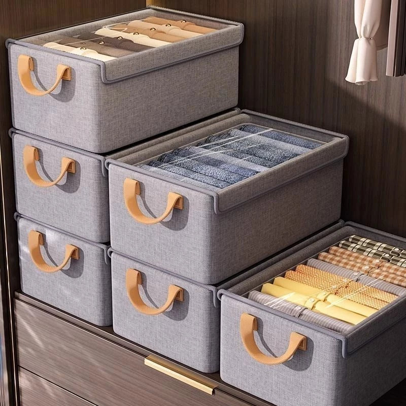 Caixa organizadora dobrável com tampa transparente e alças reforçadas, ideal para armazenar e organizar roupas, cobertores, acessórios e diversos objetos com praticidade.